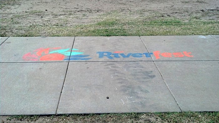 Riverfest logo spray painted on city sidewalk